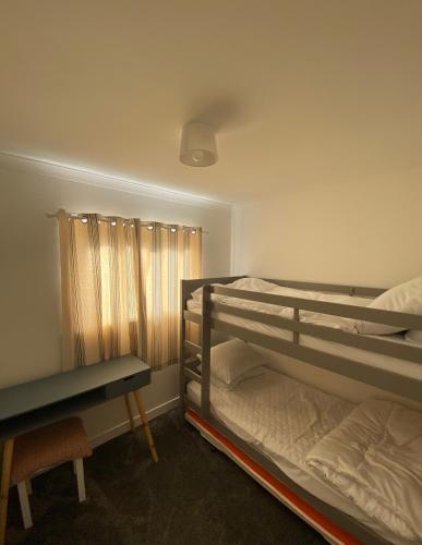 a bedroom with two bunk beds and a desk at 95 Sundowner, Hemsby, Norfolk in Hemsby