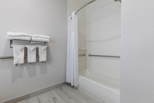 a bathroom with a shower and white towels at Comfort Suites Lombard - Addison in Lombard