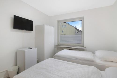 a white bedroom with two beds and a window at Apartment mit Balkon in Witten in Witten
