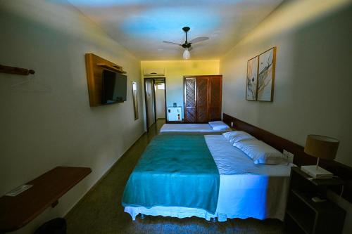1 dormitorio con 2 camas y ventilador de techo en Pousada Cia do Peixe en Marataizes