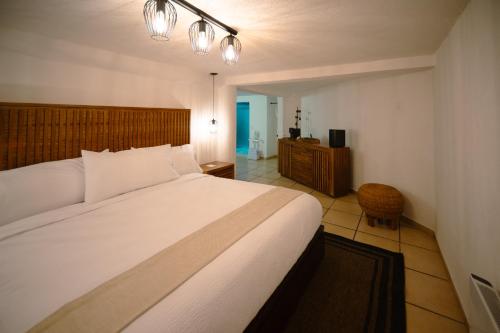 ein Schlafzimmer mit einem großen weißen Bett in einem Zimmer in der Unterkunft BOTANIQ HOTEL BOUTIQUE in Valle de Bravo