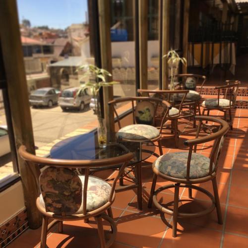 a row of tables and chairs sitting in front of a window at Hotel NASS Pinar del Lago in Cuenca