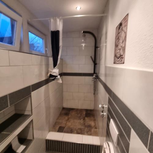 uma casa de banho com uma cabina de duche ao nível do chão e um lavatório. em Kiezloft em Hamburgo