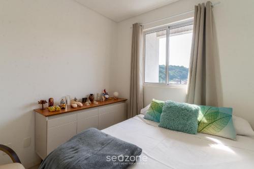 1 dormitorio con cama y ventana en EAO - Apartamentos completos em Joinville/SC, en Joinville