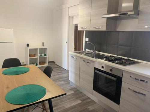 uma cozinha com uma mesa e um fogão forno superior em Suoru Maria Apartments em Chiaramonte Gulfi