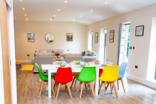 a dining room with a table and colorful chairs at The Kennels in Hexham