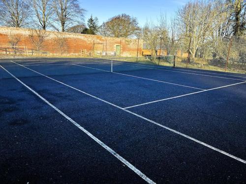 an empty tennis court with a net on it at The Kennels in Hexham