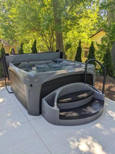 a bath tub with a toilet sitting on a sidewalk at Hot Tub Beach Retreat in Grand Bend in Grand Bend