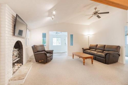 a living room with two leather couches and a fireplace at Hot Tub Beach Retreat in Grand Bend in Grand Bend
