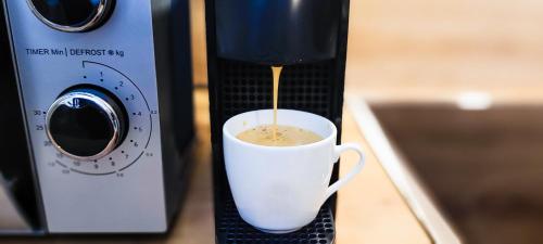a coffee maker is pouring coffee into a cup at KOMM - Zentral- Bahnhof- Congress CCS- Parkplatz in Suhl