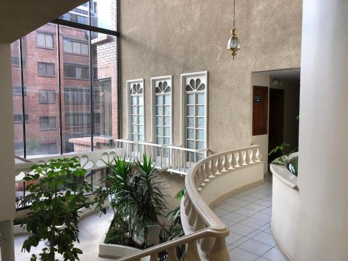a balcony with a bench and plants in a building at Hotel NASS Pinar del Lago in Cuenca