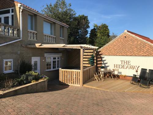 a patio with a wooden deck and a building at The Hideaway Thorpe Thewles in Thorpe Thewles