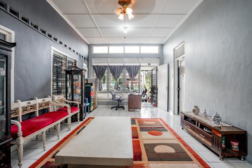パダンにあるSUPER OYO Gandaria Guest House Near Masjid Raya Sumatera Baratのリビングルーム(赤いソファ、テーブル付)