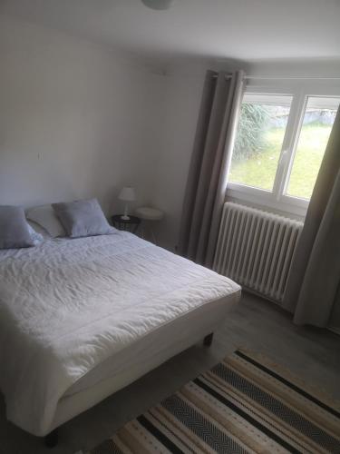 1 dormitorio con cama y ventana grande en Appartement T2 Bagnère de bigorre, en Bagnères-de-Bigorre