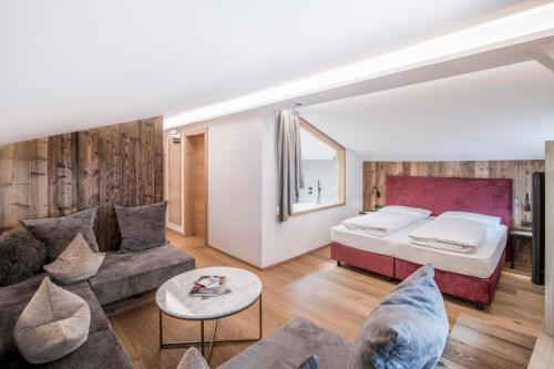 - un salon avec un lit et un canapé dans l'établissement Hotel Wieser, à Campo di Trens