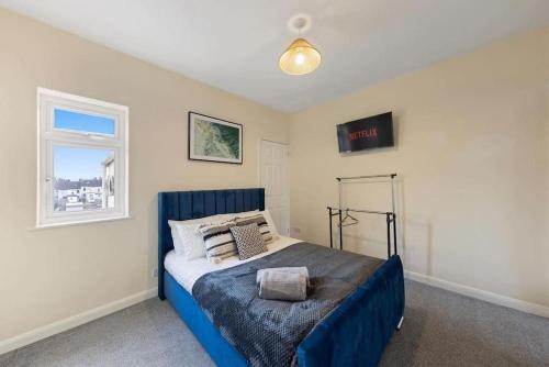 ein Schlafzimmer mit einem blauen Bett und einem Fenster in der Unterkunft Serenity House in Chatham