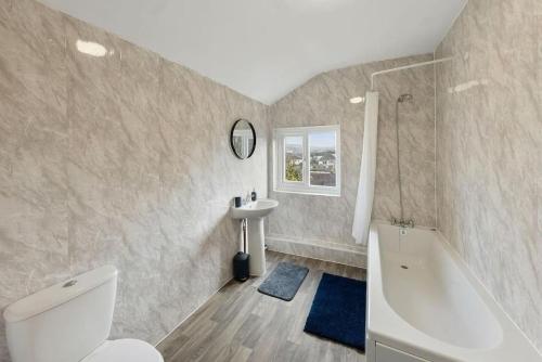 ein Badezimmer mit einem WC, einem Waschbecken und einer Badewanne in der Unterkunft Serenity House in Chatham