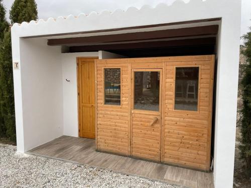 a garage with wooden doors on a white wall at Casas Demi Dos in Vélez Blanco
