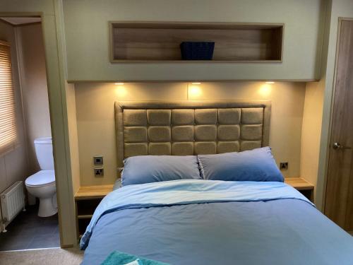 a bedroom with a bed and a toilet at Bluebell in Ferndown