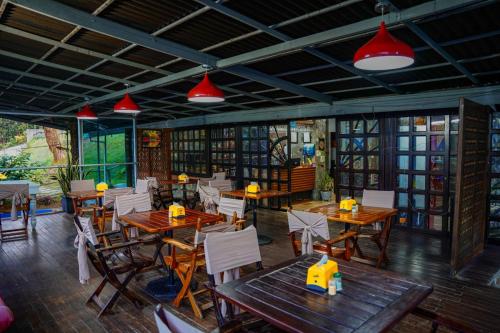 un restaurante con mesas y sillas de madera y luces rojas en FINCA HOTEL SANTO TOMAS REAL en Rionegro