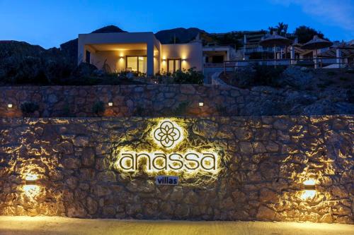 a sign on a stone wall in front of a house at Anassa Villas in Keratokampos