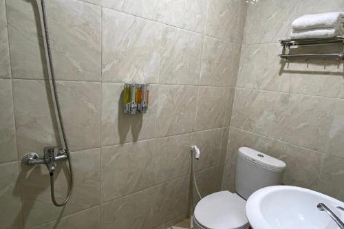 a bathroom with a shower with a toilet and a sink at SUPER OYO Gandaria Guest House Near Masjid Raya Sumatera Barat in Padang