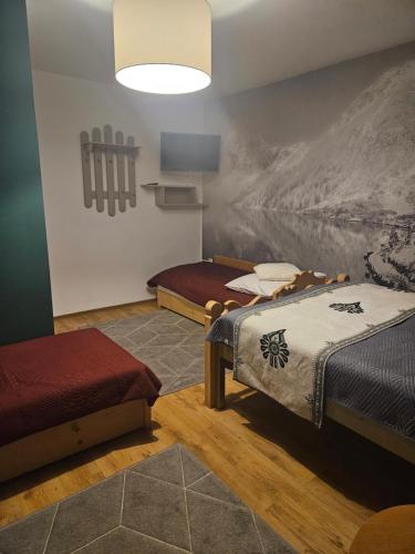 twee bedden in een kamer met een schilderij aan de muur bij HALNY in Białka Tatrzanska