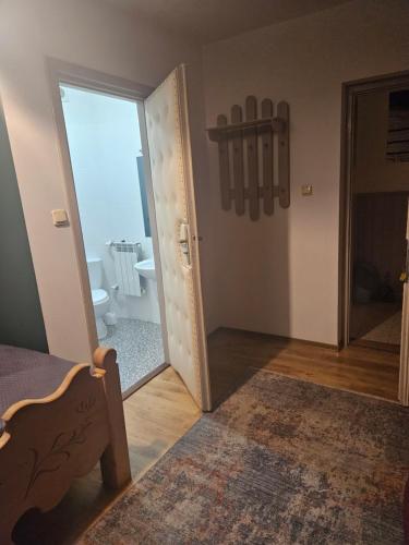 een slaapkamer met een deur naar een badkamer bij HALNY in Białka Tatrzanska