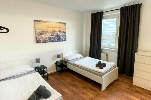 sypialnia z 2 łóżkami i oknem w obiekcie Cosy flat with TV & WLAN in Halle w mieście Angersdorf