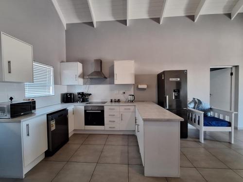 a kitchen with white cabinets and a counter top at 6 On Bloumagriet in St Helena Bay