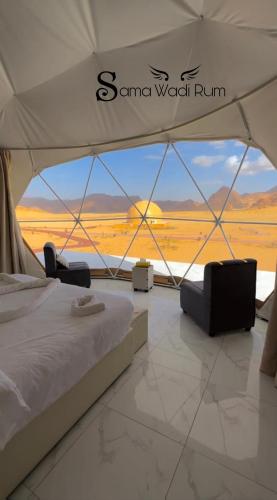 a bed in a tent with a view of the desert at Sama Wadi Rum in Wadi Rum