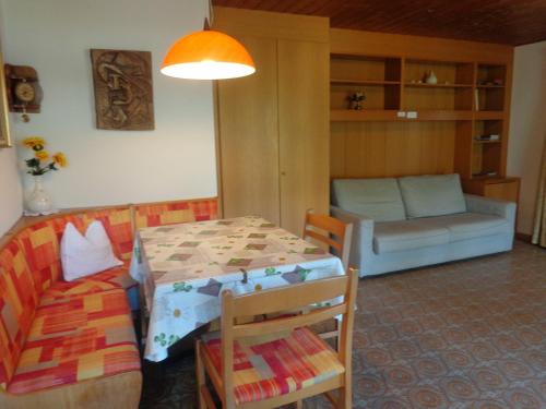 a living room with a table and a couch at Haus Talblick "Envy" Ferienwohnung in Naturno