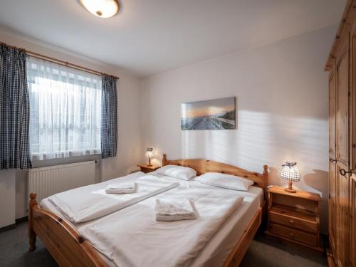 a bedroom with a large bed with white sheets at Ferienwohnanlage Brünnstein Kaiserhimmel mit Schwimmbad und Sauna in Oberaudorf