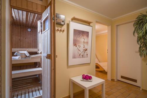 einen Flur mit einem Tisch und ein Zimmer mit einem Bett in der Unterkunft Bergschlössl - Massionettwohnung 16 in Oberaudorf