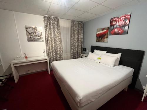 una camera da letto con un grande letto bianco e una finestra di Le Divona a Divonne-les-Bains