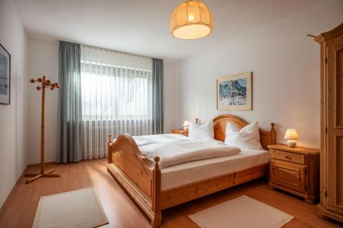 ein Schlafzimmer mit einem Bett und einem großen Fenster in der Unterkunft Ferienwohnanlage-Oberaudorf F 2mit Hallenbad und Sauna in Oberaudorf
