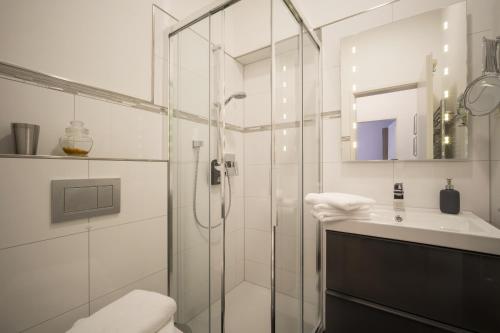 オーバーアウドルフにあるVilla Stiglohのバスルーム(ガラス張りのシャワー、シンク付)