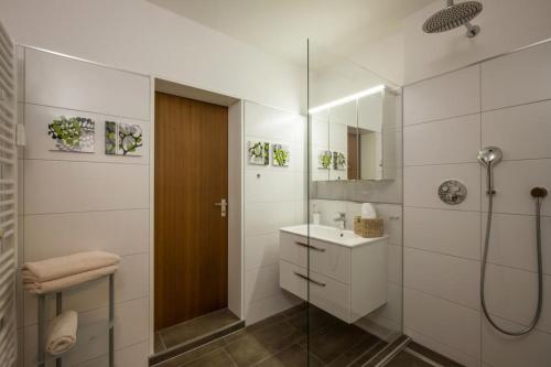 a white bathroom with a shower and a sink at Bergschlössl - Maissonettwohnung 14 in Oberaudorf