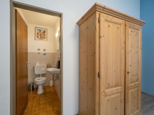 ein Badezimmer mit einem WC und einer Holztür in der Unterkunft Bergschlössl - Massionettwohnung 12 in Oberaudorf
