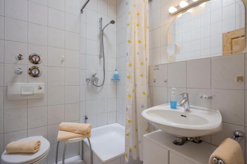 ein weißes Bad mit einem Waschbecken und einer Dusche in der Unterkunft Appartement Nr. 37 in Oberaudorf