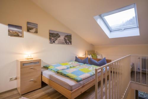 een kleine slaapkamer met een bed en een dakraam bij Bergschlössl - Maissonettwohnung 15 in Oberaudorf