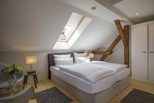 a bedroom with a large white bed with a skylight at Villa Kaiser in Auerbach