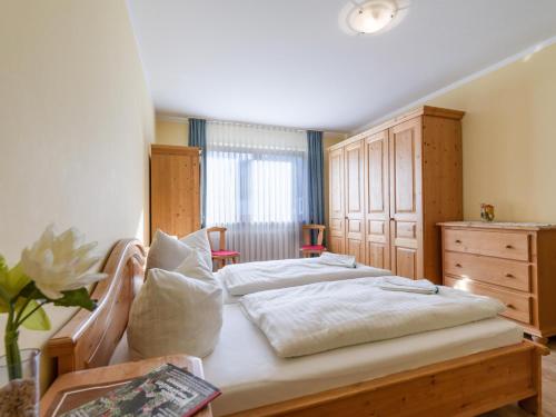 een slaapkamer met 2 bedden en een dressoir bij Ferienwohnanlage Oberaudorf E5 mit Hallenbad und Sauna in Oberaudorf