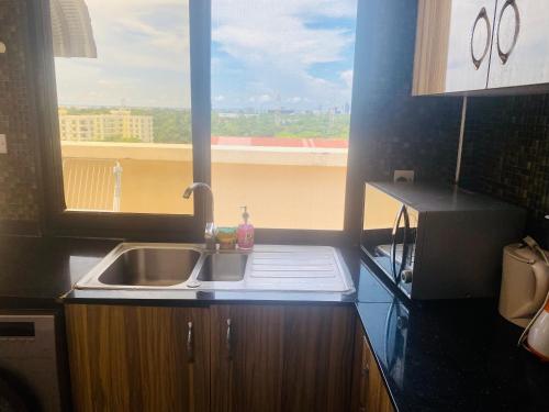 a kitchen counter with a sink and a window at Penthouse Apartment Masaki in Dar es Salaam