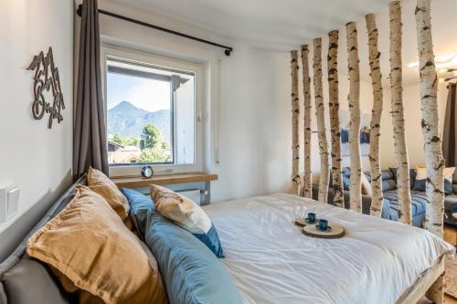 Bett in einem Zimmer mit Fenster und einem Bett mit Kissen in der Unterkunft Rosel s Mountain Lodge in Oberaudorf
