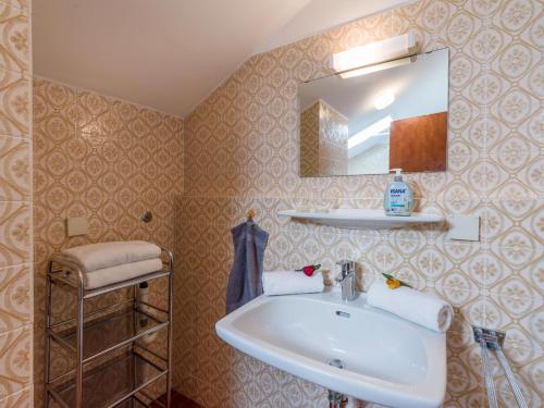 La salle de bains est pourvue d'un lavabo et d'un miroir. dans l'établissement Ferienwohnanlage Oberaudorf C7 mit Hallenbad und Sauna, à Oberaudorf