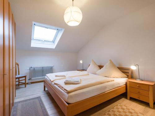 um quarto com uma cama grande e uma janela em Ferienwohnanlage Oberaudorf E7 mit 2 Schlafzimmer und Hallenbad em Oberaudorf