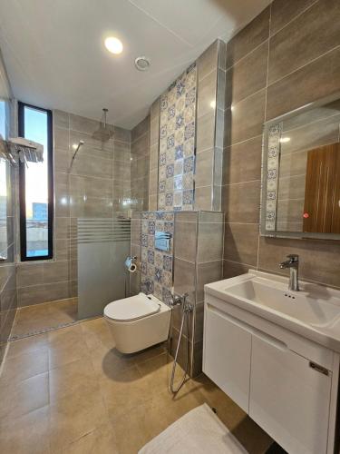 ein Bad mit einem WC und einem Waschbecken in der Unterkunft Sarok Hotel in Dohuk