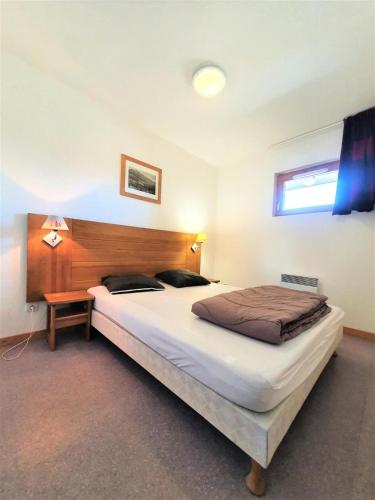 une chambre avec un grand lit avec une tête de lit en bois dans l'établissement Résidence Les Toits Du Devoluy - APPARTEMENT 6 PERSONNES BALCON EXPO SUD MAE-8604, à Saint-Étienne-en-Dévoluy