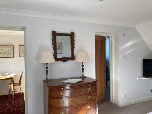 a room with two lamps on a dresser and a mirror at Trinity House in Broadwell